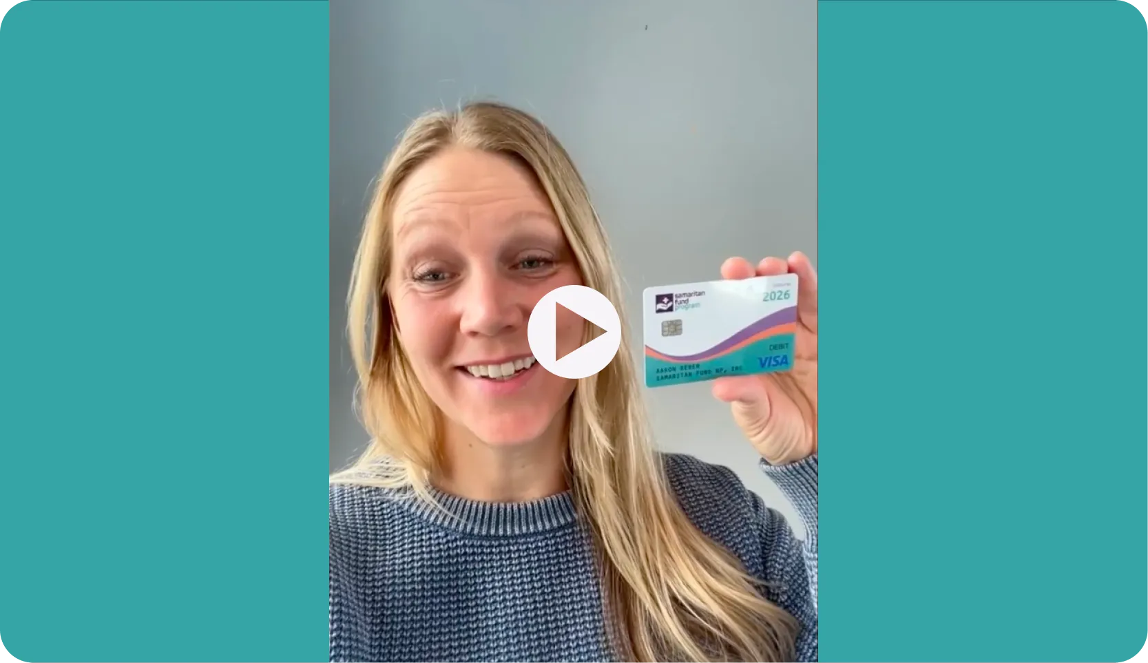 Tana Jones smiles while holding her Samaritan Fund Program Visa debit card.