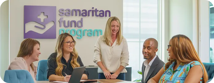 Samaritan Fund Program team members meeting around a conference table in the office