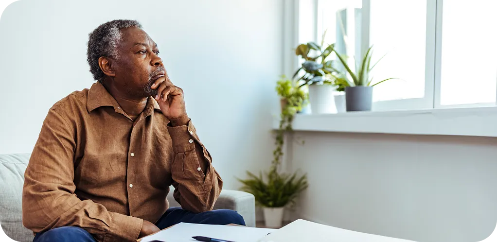 A man sitting at home reviewing medical paperwork